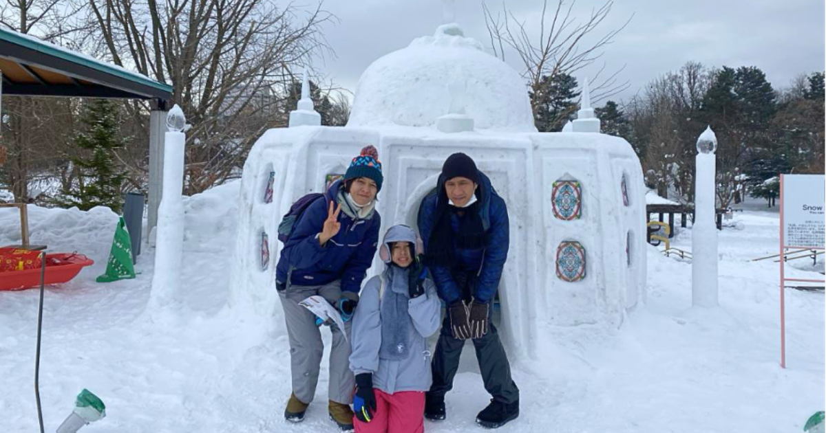 A muslim family in three people pose in front of a snow mosque displayed at Asahikawa Winter Destival